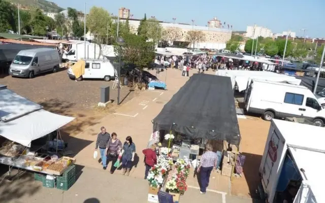 Puestos del mercadillo semanal de Puertollano con clientes entre los tenderetes