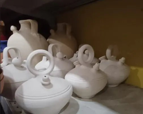 Botijos de barro preparados para el taller infantil de pintura