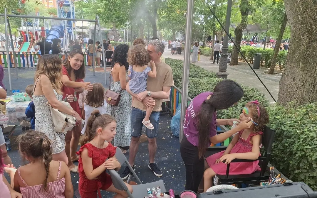 Niños y niñas participan en talleres de manualidades y pintacaras en el Paseo de San Gregorio durante las fiestas de Puertollano