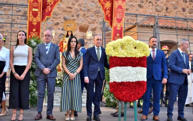 Vecinos depositando flores ante la Virgen de Gracia en la ofrenda floral de las fiestas patronales