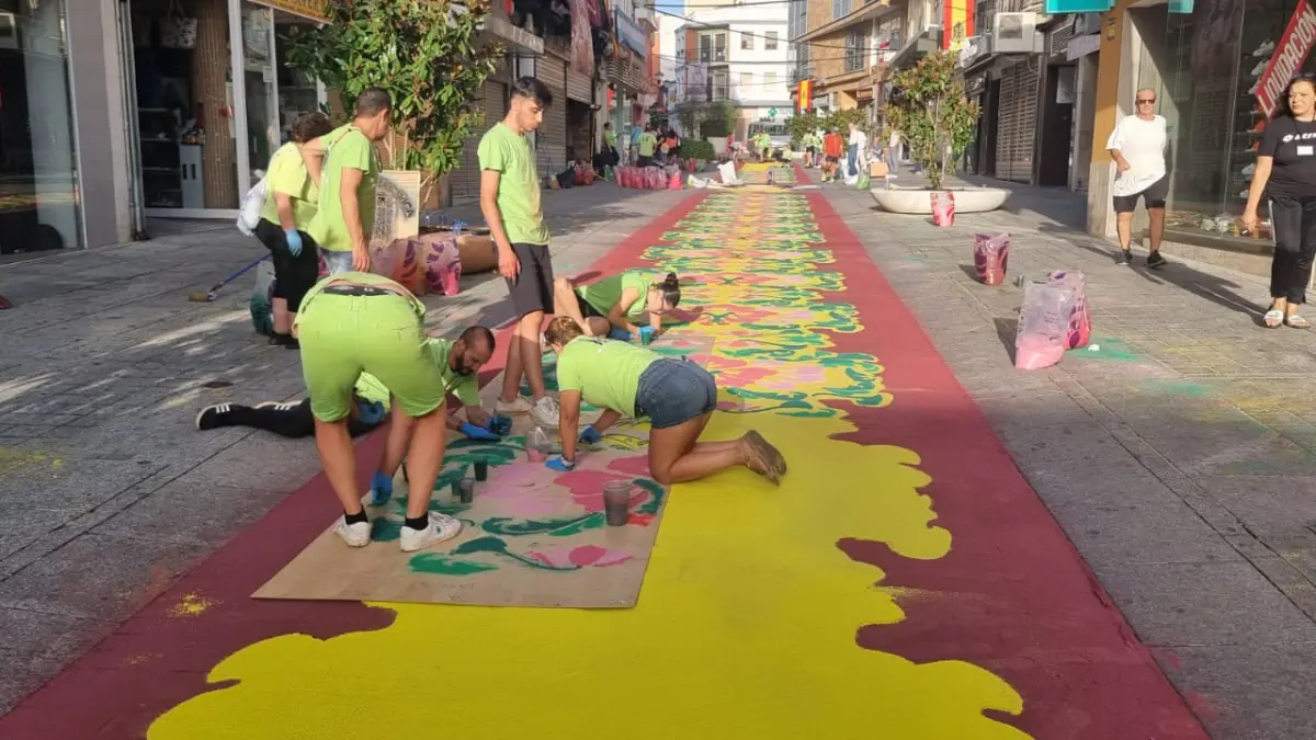 Voluntarios elaborando alfombras de sal coloreada en la calle Calzada de Puertollano